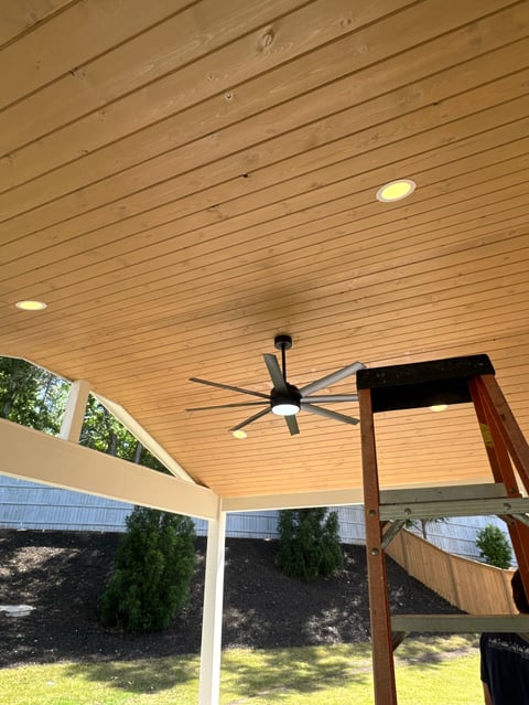 Covered patio with wood ceiling, ceiling fan, recessed lighting, and wood beam support structure overlooking backyard